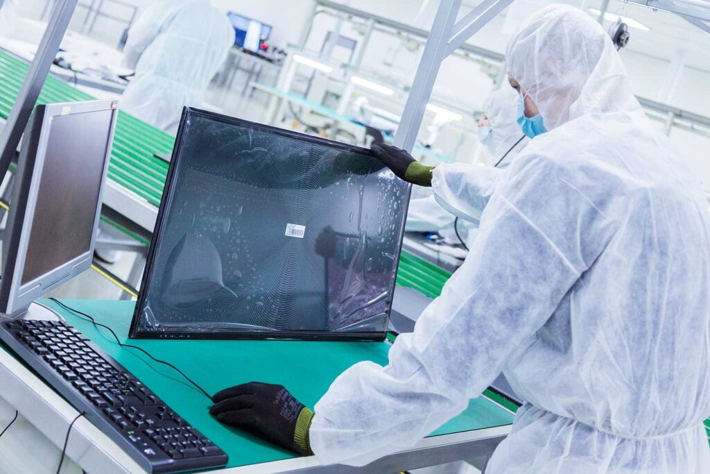 Worker in clean suit inspecting a screen